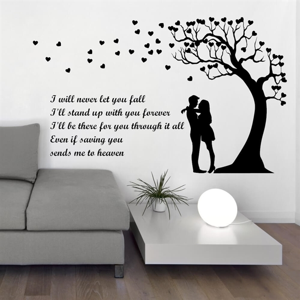 En romantisk wallsticker med teksten: I\'ll never let you fall. Ved siden af er der en illustration af et træ og et kyssende par.